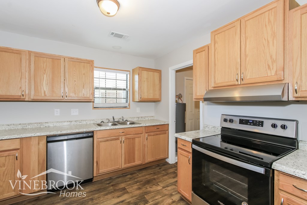 a kitchen with wooden cabinets and stainless steel appliances